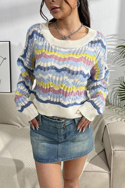 a woman standing in front of a couch wearing a sweater