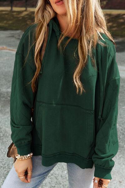a woman wearing a green hoodie and jeans