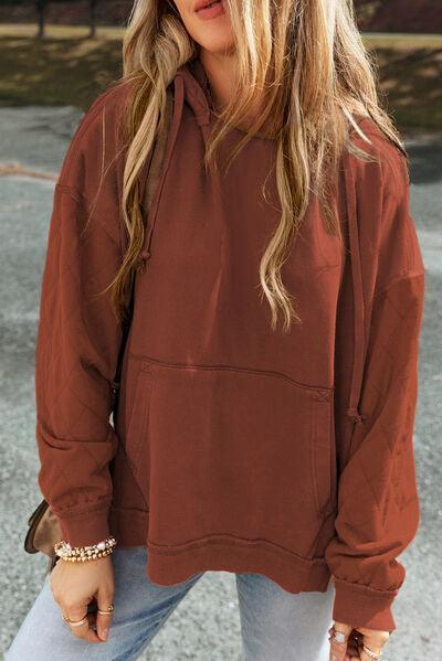 a woman wearing a brown hoodie and jeans