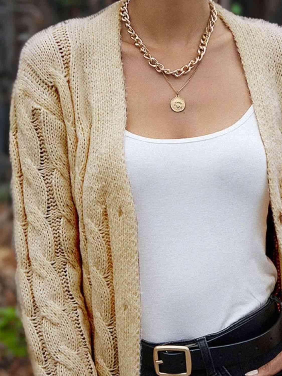 a woman wearing a white tank top and a cardigan