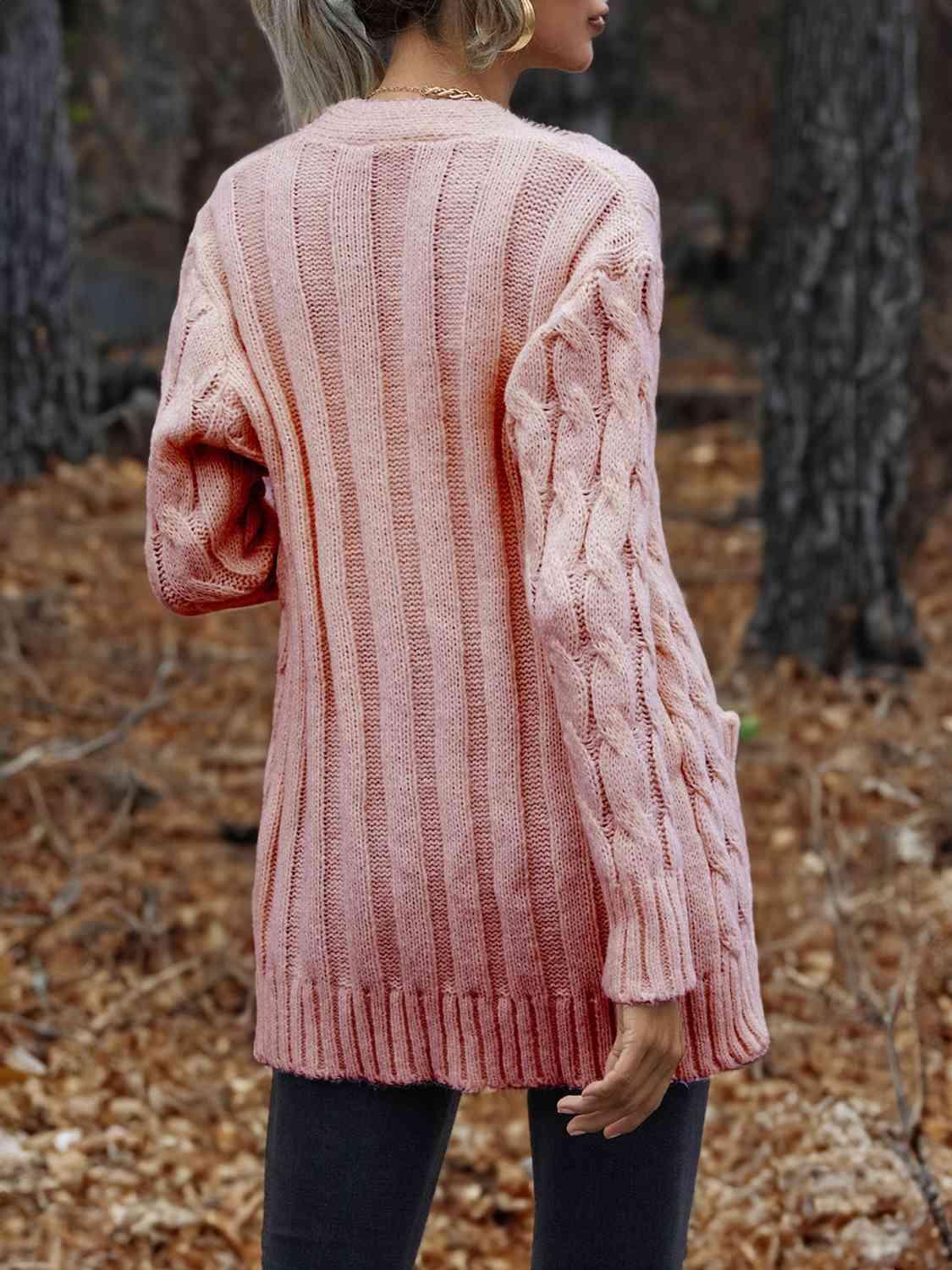 a woman wearing a pink sweater in the woods