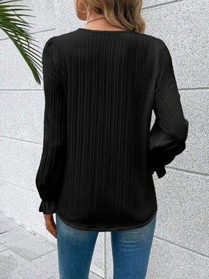 a woman wearing a black blouse and jeans