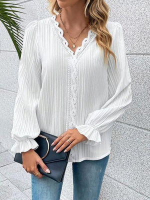 a woman wearing a white blouse and jeans