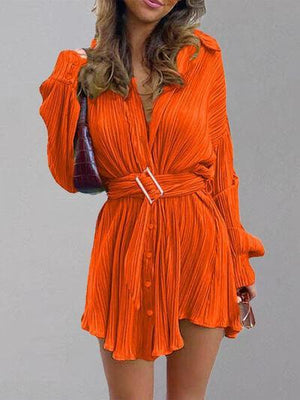 a woman in an orange dress posing for a picture