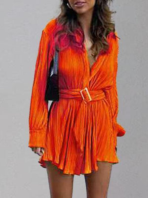 a woman in an orange dress is posing for a picture