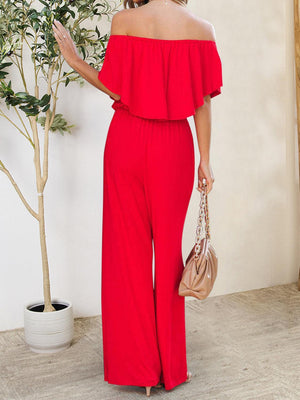 a woman in a red jumpsuit holding a purse