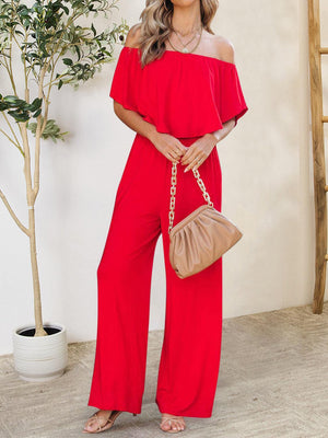 a woman in a red jumpsuit holding a purse
