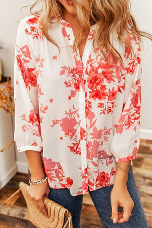 a woman wearing a white and red floral shirt