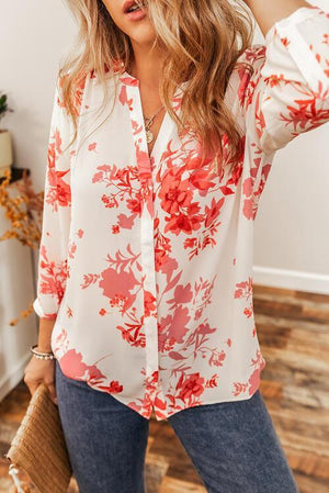 a woman wearing a white and red floral shirt