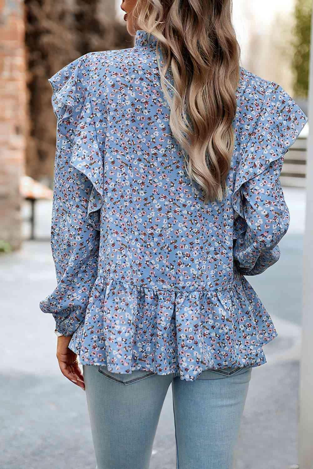 a woman wearing a blue floral blouse and jeans