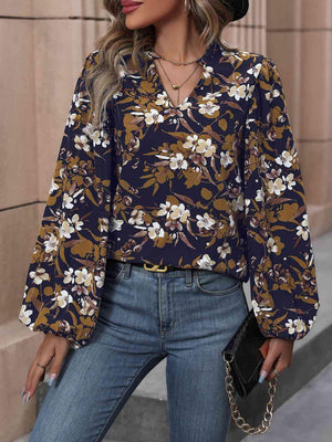 a woman wearing a floral blouse and jeans