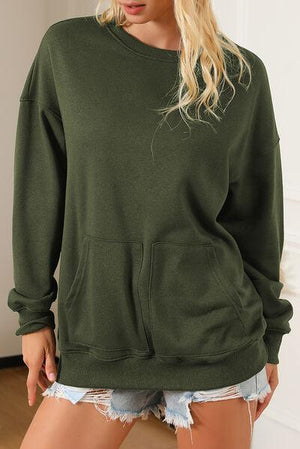 a woman wearing a green sweatshirt and ripped shorts