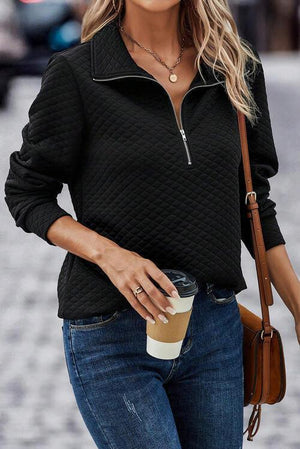 a woman wearing a black sweater and jeans