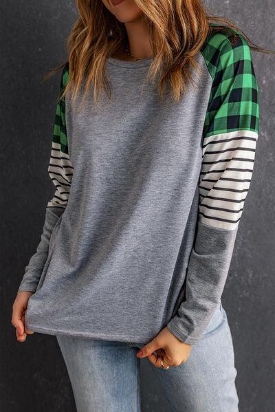 a woman wearing a grey and green plaid shirt