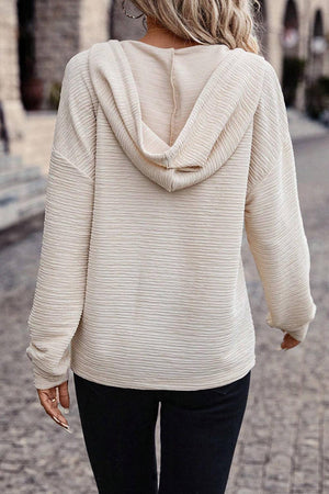 a woman walking down a street wearing a white sweater