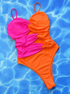 an orange and pink one piece swimsuit floating in a pool