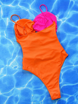 an orange and a pink one piece swimsuit in a pool