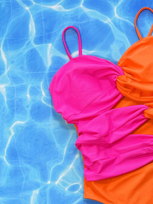 an orange and pink one piece swimsuit in a pool
