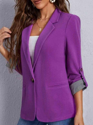 a woman wearing a purple blazer and jeans