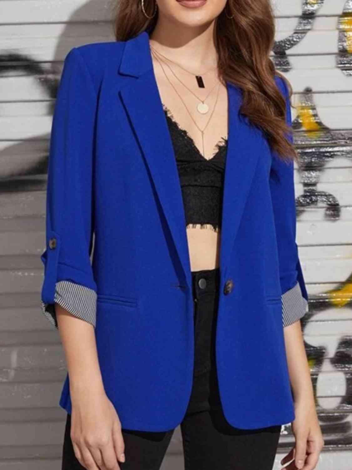 a woman wearing a blue blazer and black pants