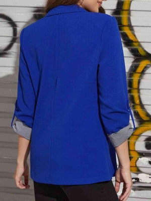 a woman wearing a blue jacket and black pants