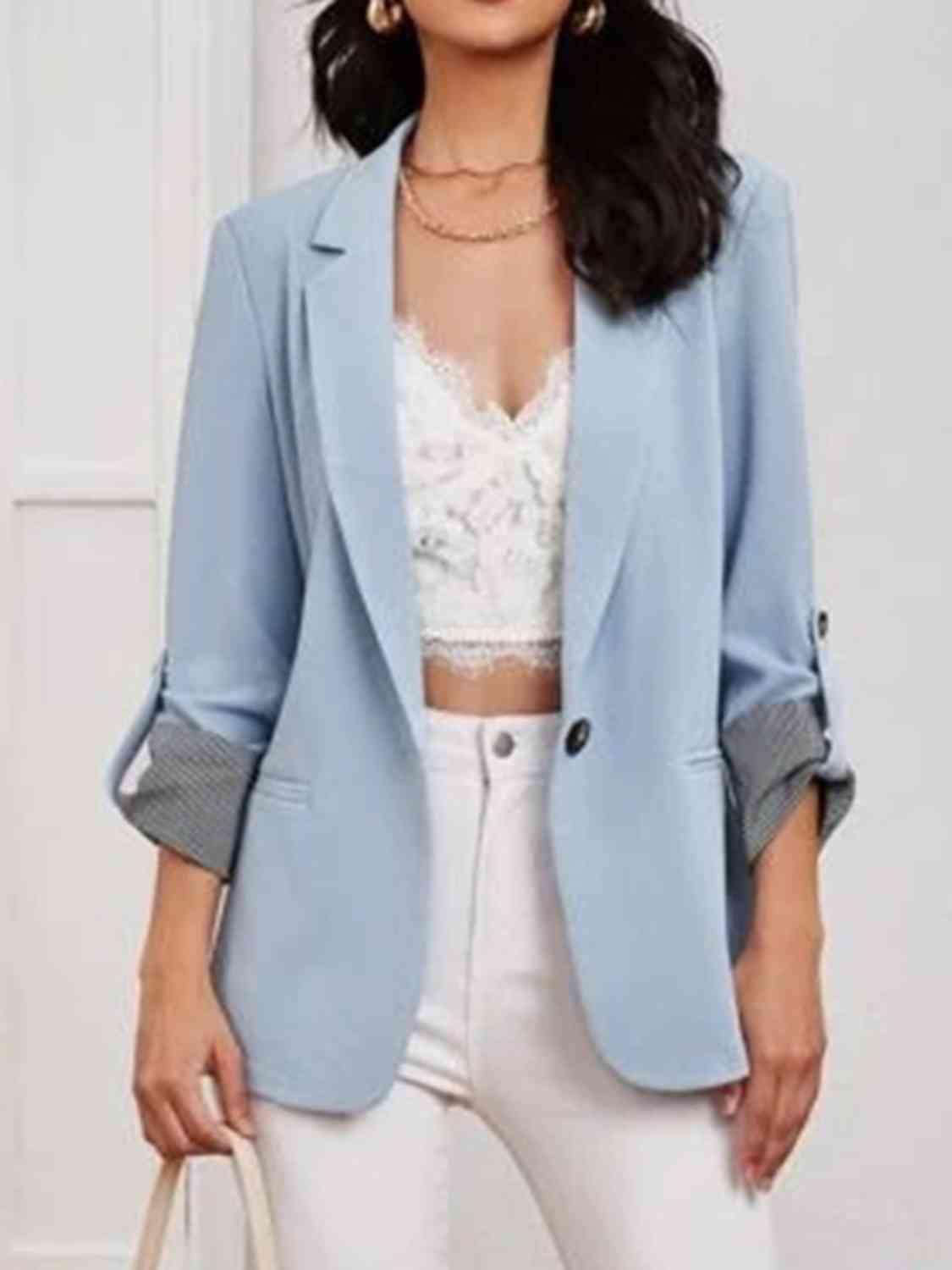 a woman wearing a blue blazer and white pants