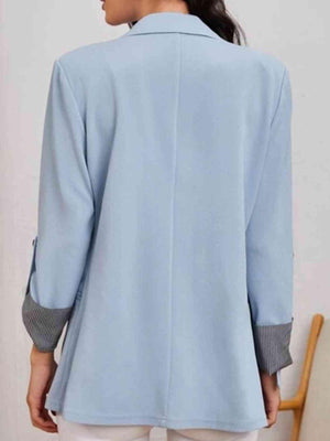 a woman wearing a blue jacket and white pants