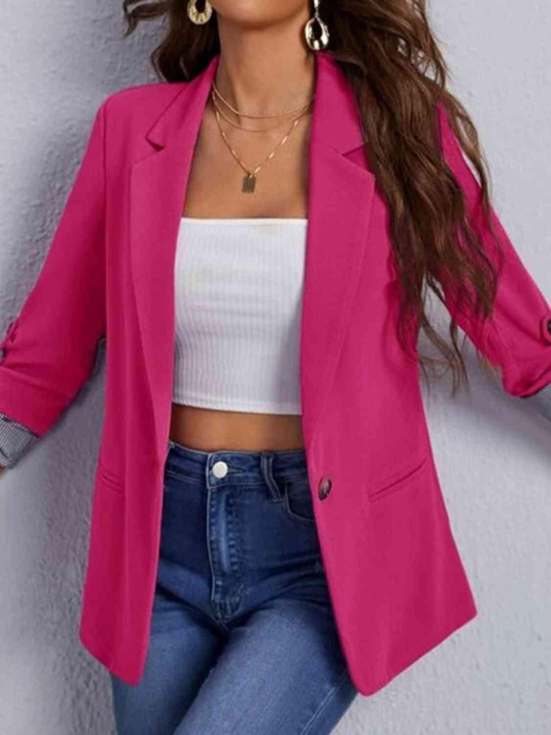 a woman wearing a pink blazer and jeans