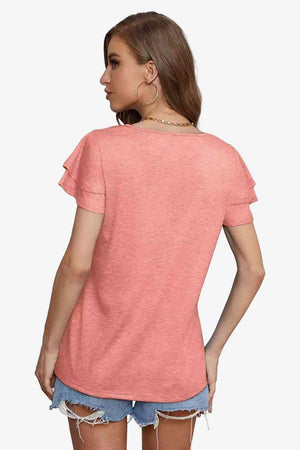 a woman wearing a pink shirt and denim shorts