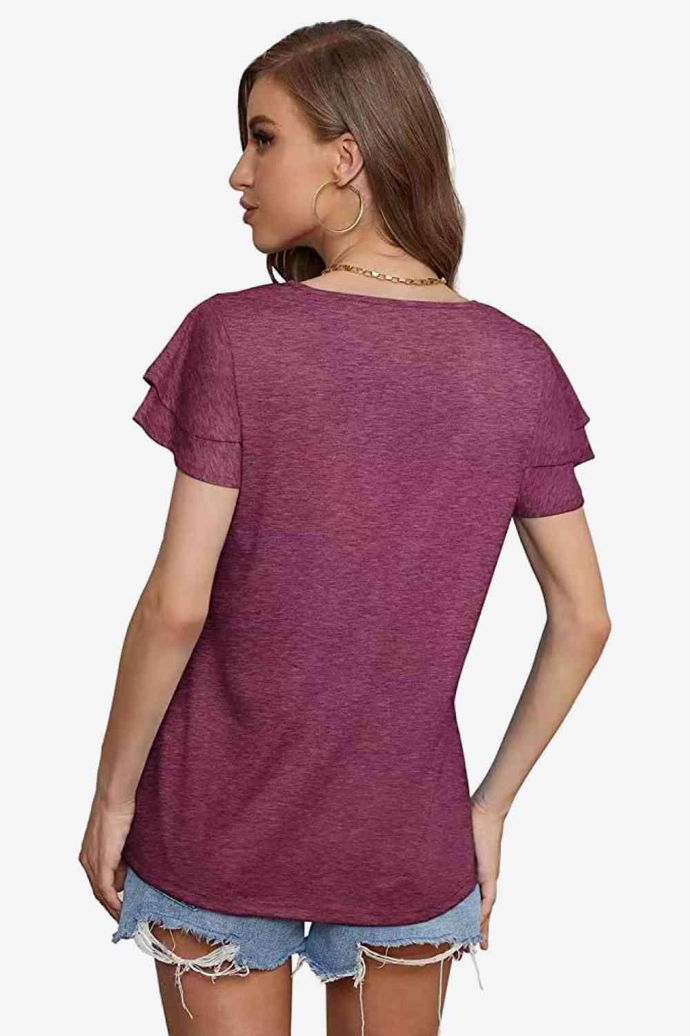 a woman wearing a purple shirt and ripped shorts