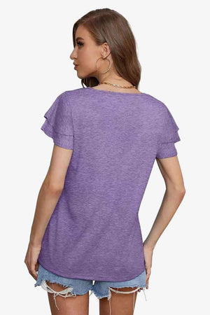 a woman wearing a purple shirt and ripped shorts