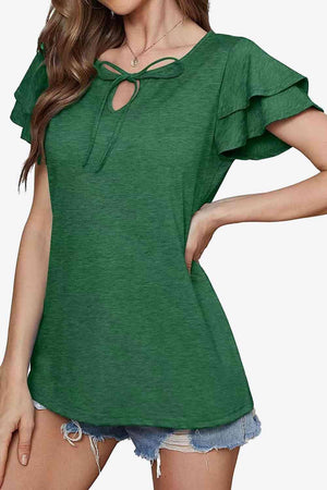 a woman wearing a green top with a cut out shoulder