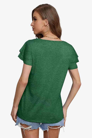 a woman wearing a green shirt and ripped shorts