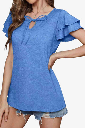 a woman wearing a blue top with a cut out shoulder