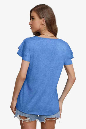 a woman wearing a blue shirt and denim shorts