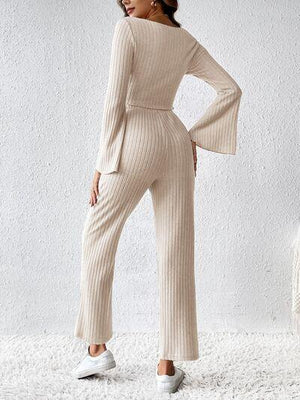 a woman in a white sweater and wide legged pants