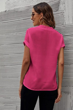a woman wearing a pink top and black pants