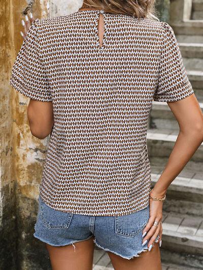 a woman wearing a short sleeved shirt and denim shorts