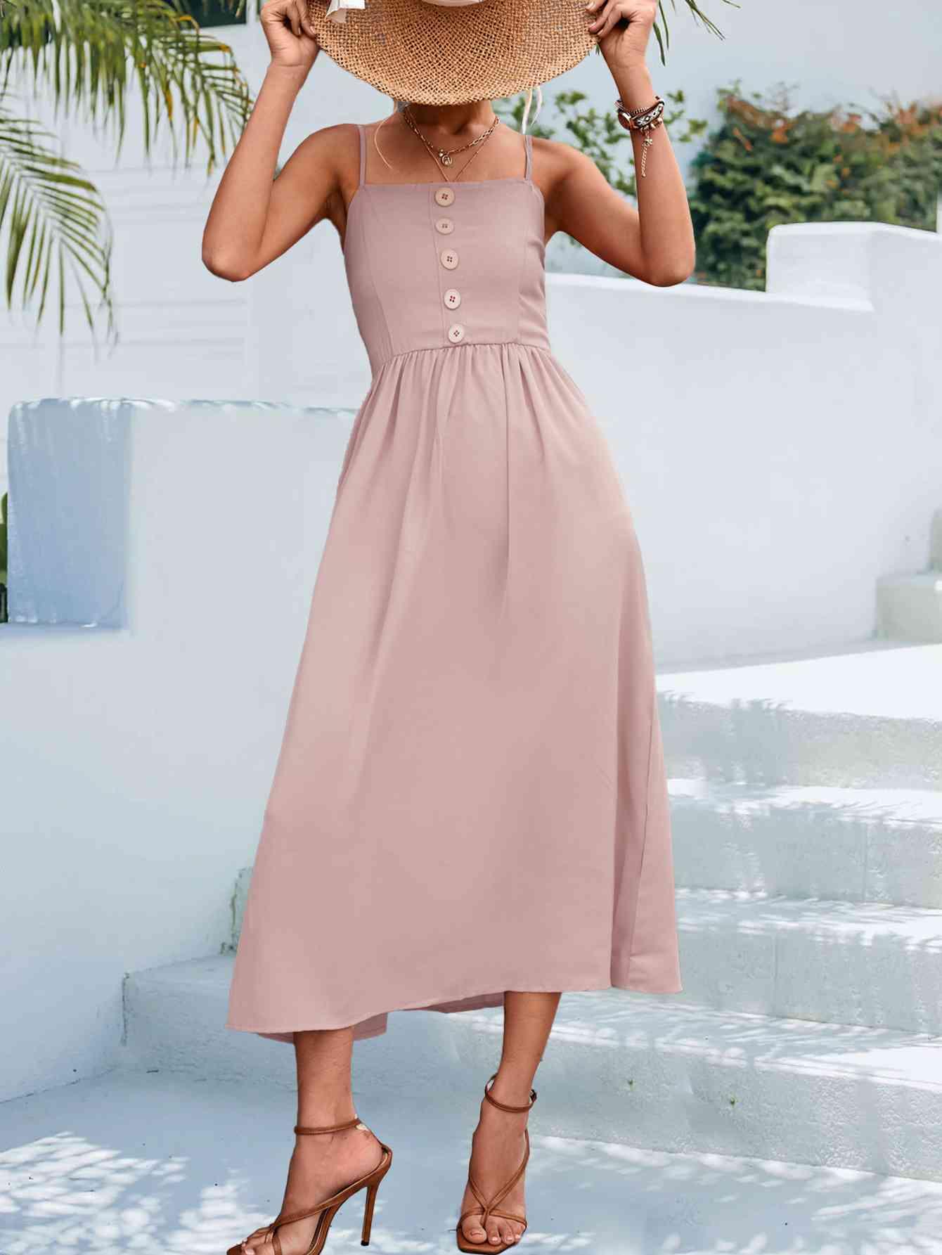 a woman wearing a pink dress and a straw hat