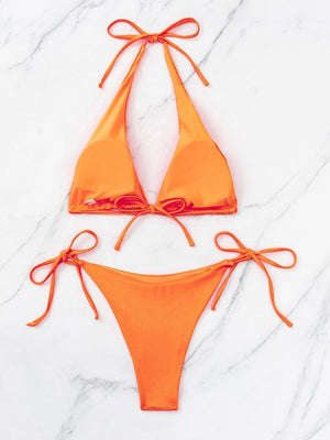 a bikini top and bottom with ties on a marble surface