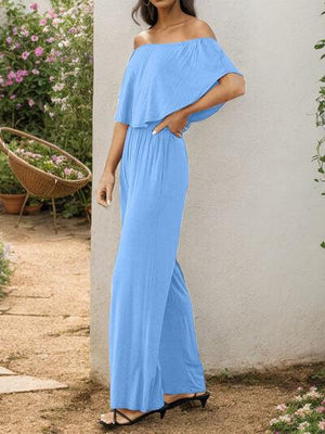 a woman in a blue jumpsuit posing for a picture