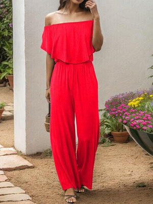 a woman in a red jumpsuit talking on a cell phone