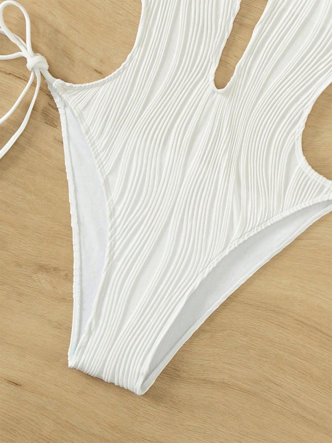 a white bikini top with a tie on a wooden surface