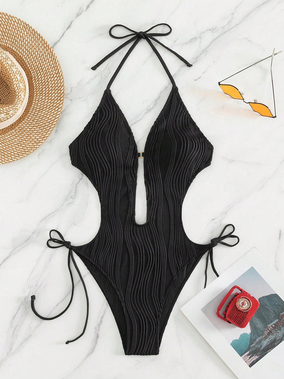 a black one piece swimsuit on a marble surface