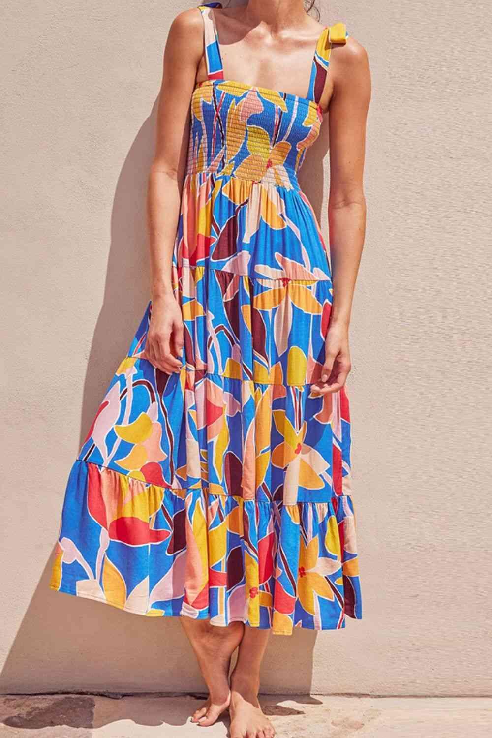 a woman standing against a wall wearing a colorful dress