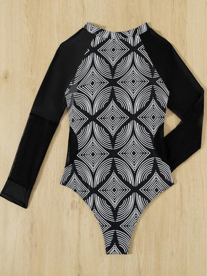 a black and white bodysuit sitting on top of a wooden floor