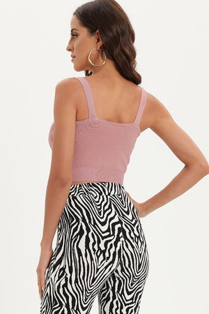 a woman wearing a pink tank top and zebra print pants