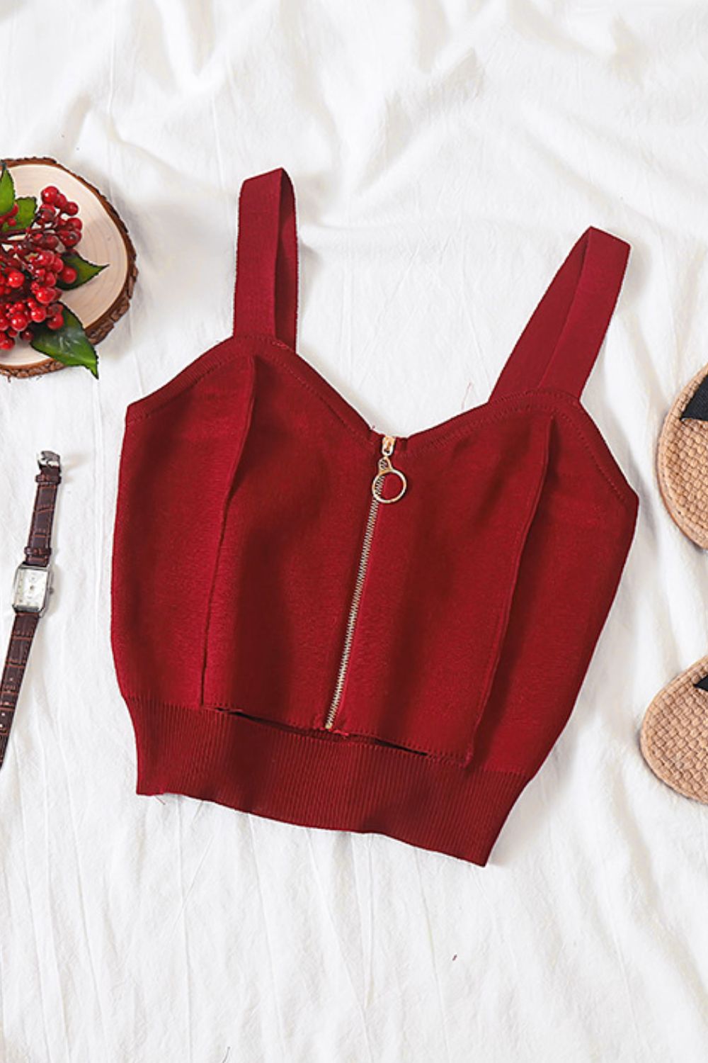 a crop top and sandals on a bed