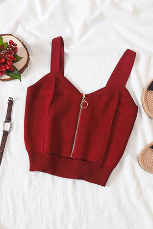 a crop top and sandals on a bed