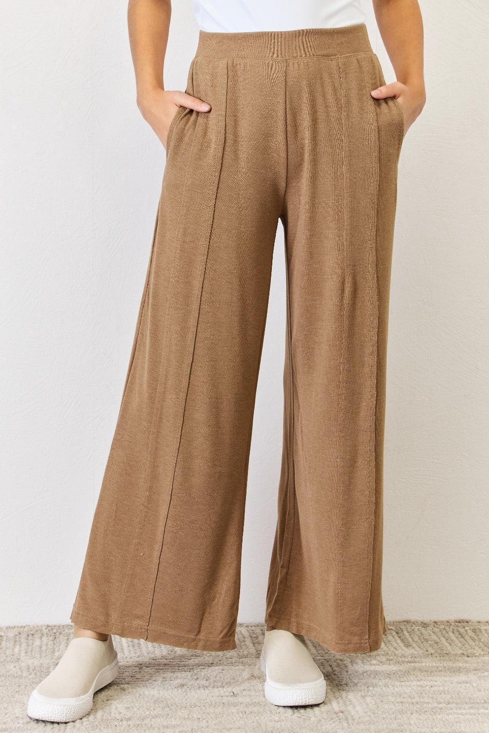 a woman in a white shirt and brown pants